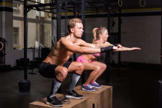 Couple de crossfitteurs effectuant un box jump