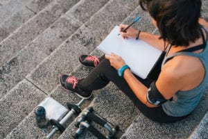 Une femme écrit ses objectifs pour adopter de bonnes habitudes au quotidien