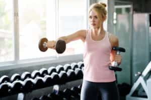 Une femme pendant une séance de musculation avec haltères