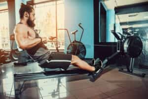 Un homme faisant du rameur dans une salle de fitness