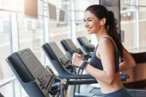 Une femme souriante sur un appareil de fitness