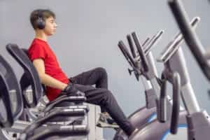 Un jeune homme de profil sur un Vélo d'Appartement Semi-Allongé