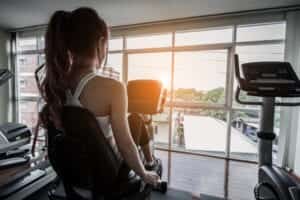 Une femme de dos sur un Vélo d'appartement semi-couché